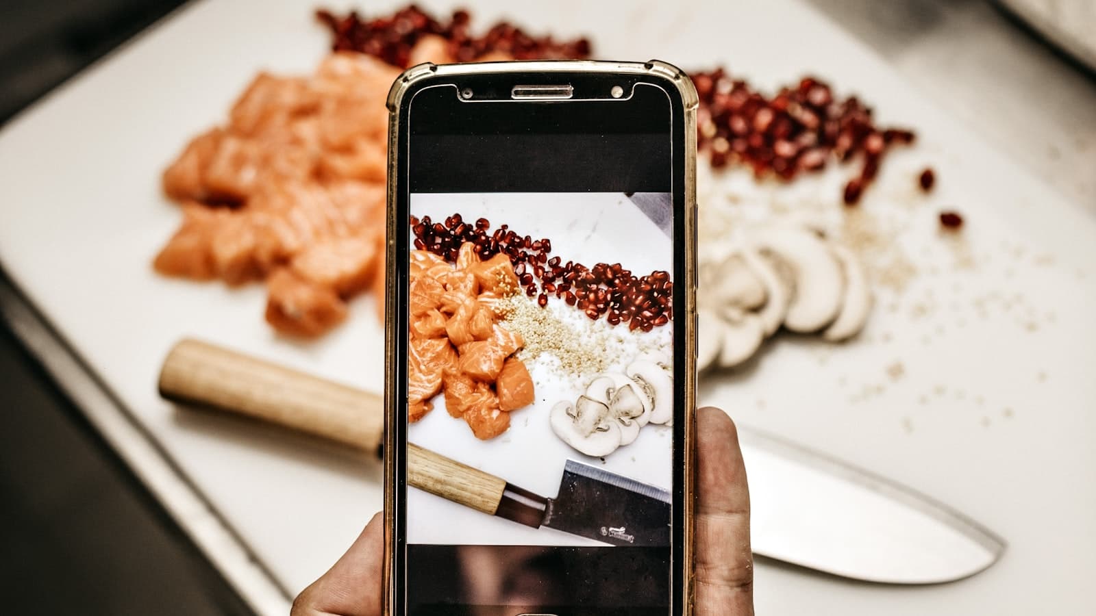 A person photographing a plate of food with a smartphone