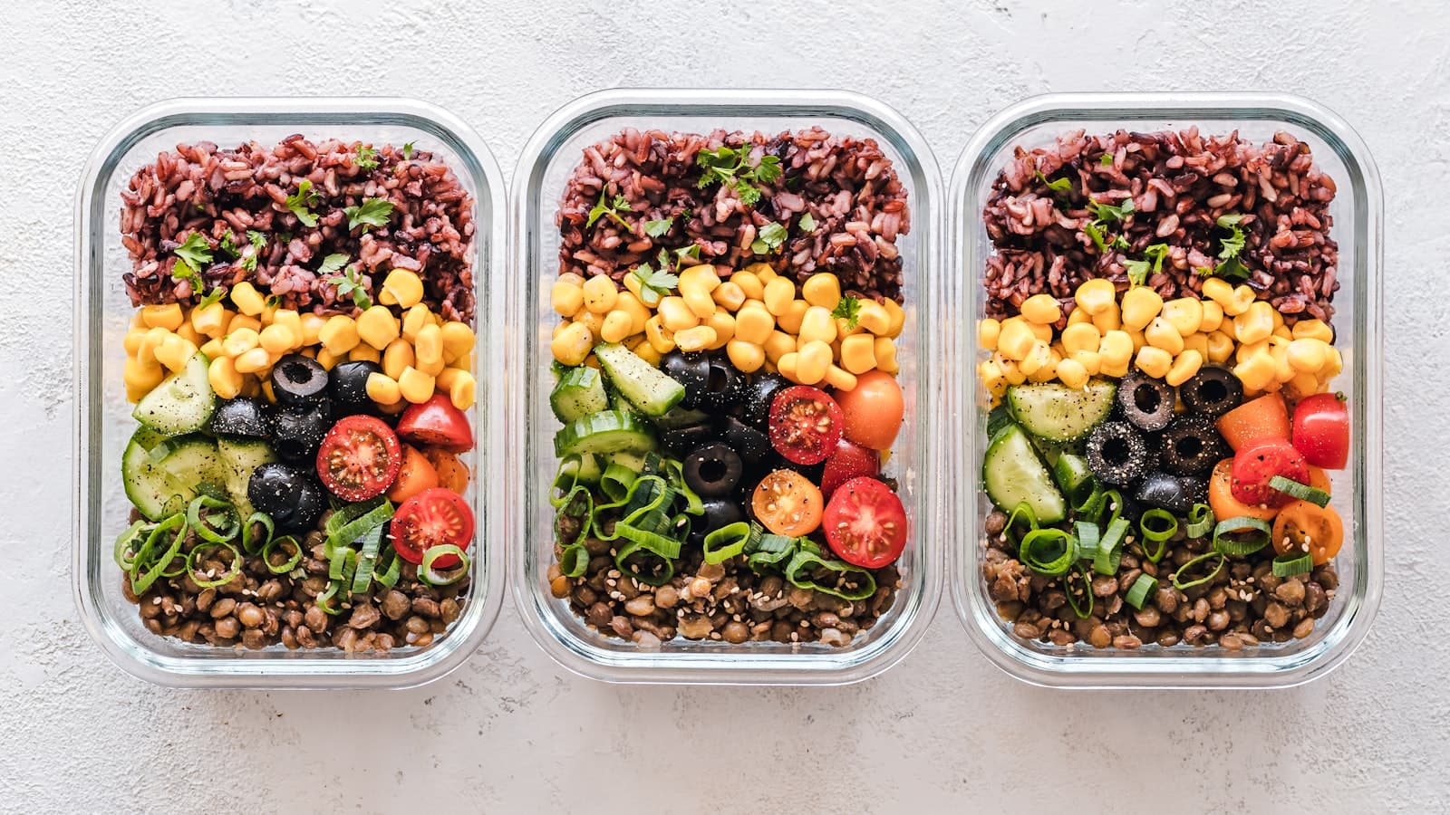 Fresh meal-prep containers with vegetables in warm light